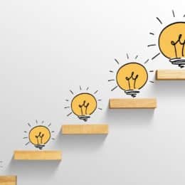 Drawn light bulbs form an ascending pattern and symbolize brainstorming brand voice guidelines for a consistent tone.
