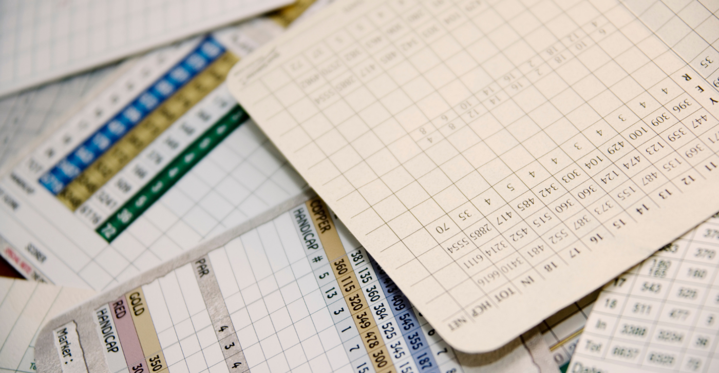 The image shows scorecards piled up in a messy way.