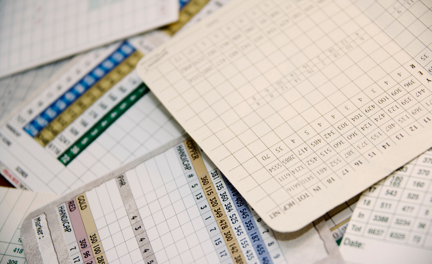 The image shows scorecards piled up in a messy way.