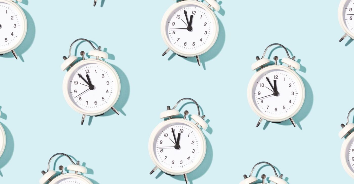 On a light blue background, lots of clocks are shown in a consistent pattern. They all show the time 11:55. They symbolize creating content faster.