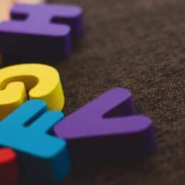 Colorful wooden letters on dark background smybolize grammar guides and style guides.