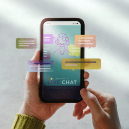 On a grey background is a mobile phone with different colored speech bubbles and a cartoon of a person to symbolize self-service content and its ability to reduce customer support calls.
