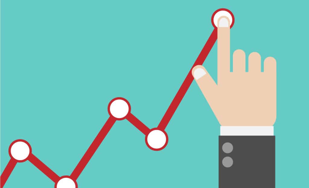 A hand points to a peak on a red, upward-trending line graph against a teal background.
