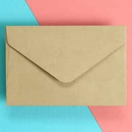On a bright blue and pink background a beige envelope is centrally displayed to represent how to write effective emails.