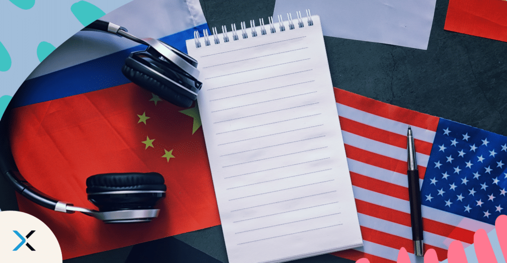 Seamless content localization starts with good source content. An image of a blank notebook and headphones and a pen on numerous countries flags.