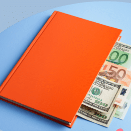 A red notebook with bank notes protuding from the pages representing a guide to content marketing for financial services.