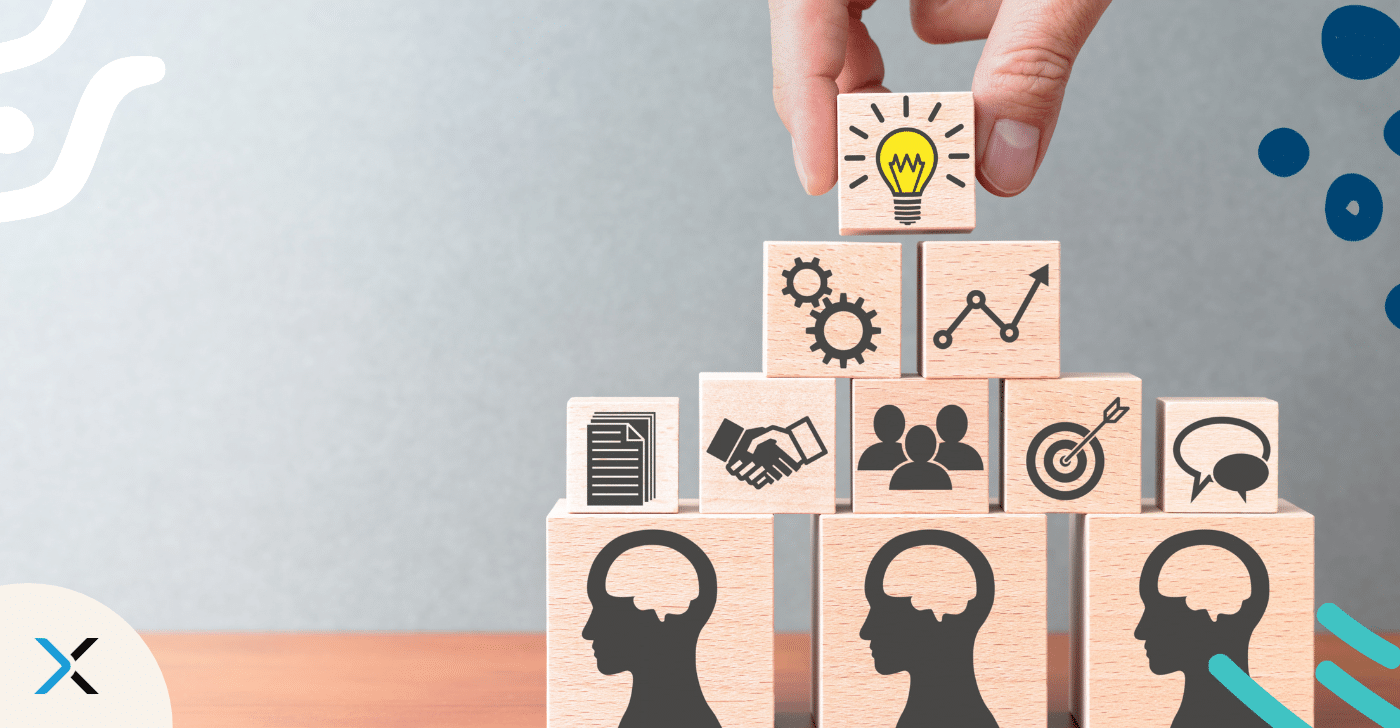 Knowledge management blog Building blogs with people printed on them in a pyramid, in a pyramid with a light bulb on top that represents building an enterprise knowledge management strategy.