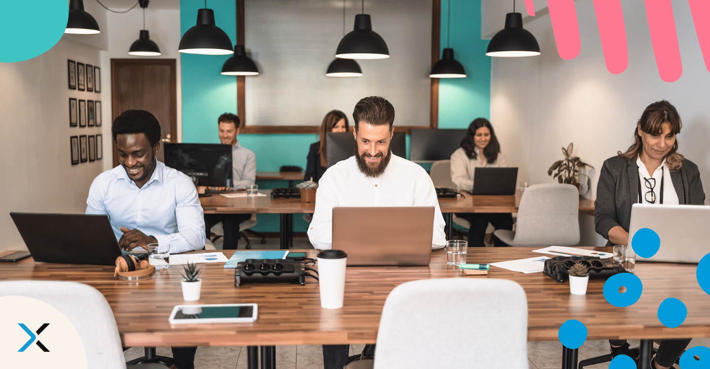Outsource content writing blog People working on laptops at a desk respresenting outsourcing non-native writers to create content.