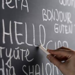 Vielsprachige Begrüßungen auf einer Tafel symbolisieren Corporate Language.